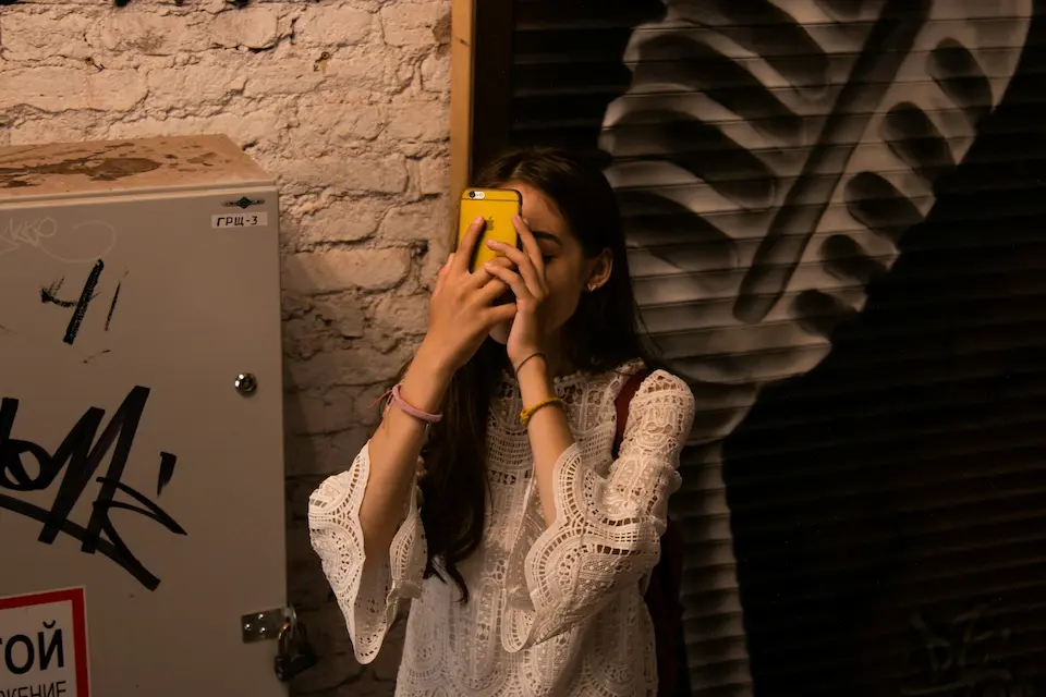 a woman holding a phone to her face, looking lost